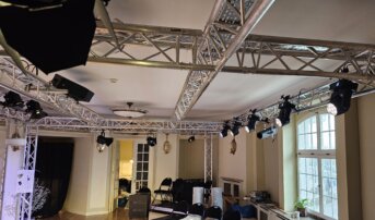Rzędy reflektorów zamontowanych na aluminiowej konstrukcji w teatrze.