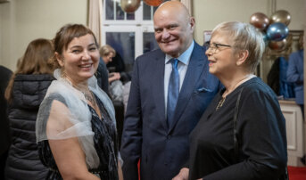 Dwie kobiety i mężczyzna stoją w tłumie na Foyer. Uśmiechają się.
