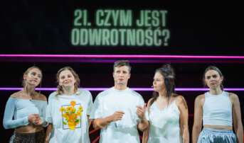 Kliknij by powiększyć zdjęcie. Alternatywny opis zdjęcia: Pięcioro aktorów stoi obok siebie na pierwszym planie. W tle są poziome linie światła i napis wyświetlany nad sceną: „Czym jest odwrotność?”